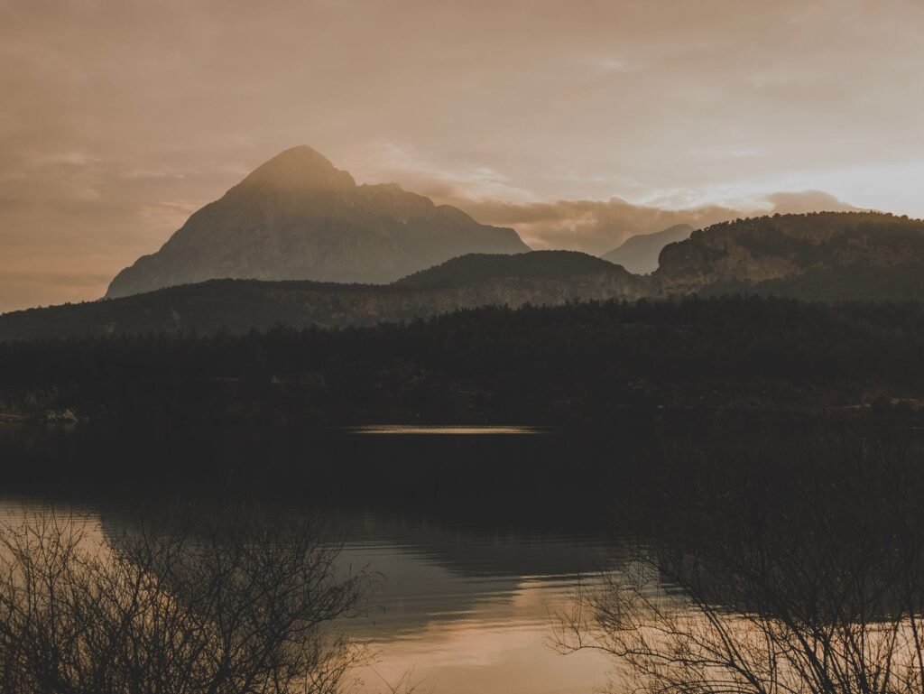 A peaceful sunrise breaking over misty mountain peaks, representing quiet surrender to God